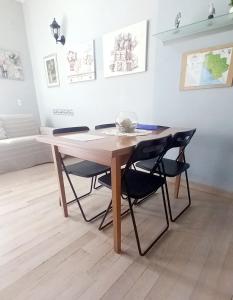 una mesa de madera con sillas negras en la sala de estar. en La Casa di Barbanella, en Grosseto