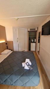 1 dormitorio con 1 cama grande con mando a distancia en Premiere Classe Bordeaux Est Lormont, en Lormont