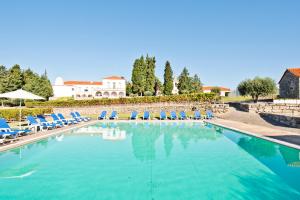 una gran piscina con sillones azules y opoulos en Flag Hotel Convento do Desagravo, en Oliveira do Hospital