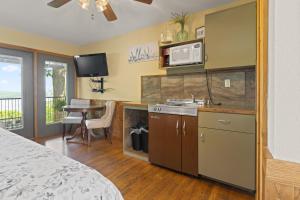 a kitchen with a bed and a table and a kitchen with a sink at Roadrunner Inn and Log Cabins in Eureka Springs