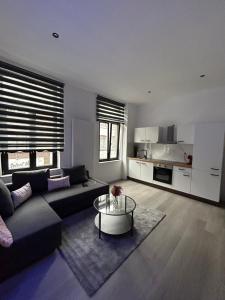 uma sala de estar com um sofá e uma mesa em Appartement de Luxe en Plein Centre de la Ville! em Liège