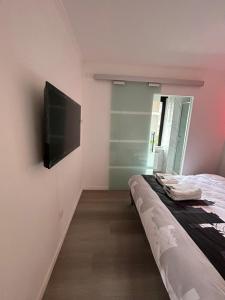 um quarto com uma cama e uma televisão de ecrã plano em Appartement de Luxe en Plein Centre de la Ville! em Liège