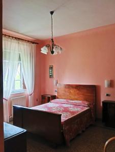 a bedroom with pink walls and a large bed at Angelini in Lucca