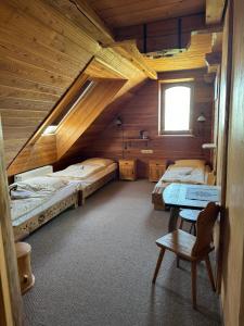 a room with two beds in a wooden cabin at Krynicka Koliba na Jaworzynie Krynickiej in Krynica Zdrój