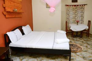 um quarto com uma cama grande com uma mesa e uma mesa; em Gorilla African Guest House em Entebbe