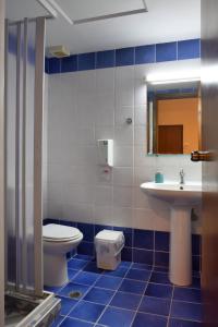 La salle de bains bleue et blanche est pourvue de toilettes et d'un lavabo. dans l'établissement Akatos Hotel, à Agia Marina