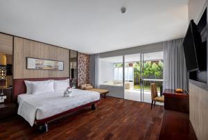 een hotelkamer met een bed en een televisie bij Sanur Resort Watujimbar in Sanur