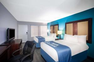 ein Hotelzimmer mit 2 Betten und einem TV in der Unterkunft Days Inn by Wyndham Mobile I-65 in Mobile