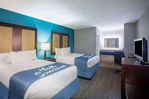 ein Hotelzimmer mit 2 Betten und einem TV in der Unterkunft Days Inn by Wyndham Mobile I-65 in Mobile