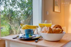 uma mesa com uma tigela de pão e copos de sumo de laranja em Studio central, proximité immédiate Aéroport em Mérignac