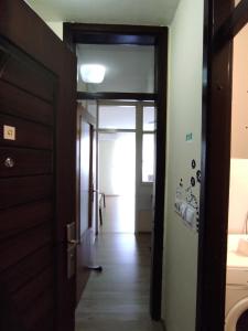 un pasillo con una puerta que conduce a un baño en Ema Apartmani, en Vinkovci