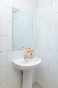 a white bathroom with a sink and a mirror at Sunlit Furnished Studio, Kisii in Kisii