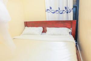 two twin beds in a room with a window at Sunlit Furnished Studio, Kisii in Kisii