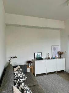 - un salon avec un canapé et un mur blanc dans l'établissement WORK&STAY - Apartamento no centro de Coimbra, à Coimbra