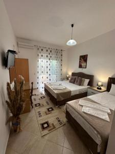 a bedroom with two beds and a tv in it at Apartments Sija in Ulcinj