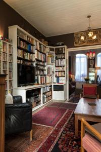 ein Wohnzimmer mit Bücherregalen gefüllt mit Büchern in der Unterkunft Camera et Caetera Chambres d'hôtes B&B in Roubaix