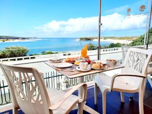 einen Tisch mit Speisen auf einem Balkon mit Meerblick in der Unterkunft Hotel HS Milfontes Beach - Duna Parque Resorts & Hotels in Vila Nova de Milfontes