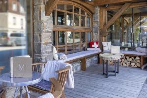 een veranda met tafels en stoelen in een gebouw bij M de Megève in Megève