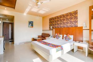 um quarto com uma grande cama branca num quarto em FabHotel Prime Devanshi Inn - Panvel em Kalamboli