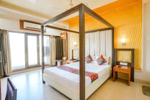 um quarto com uma cama de dossel num quarto em FabHotel Prime Devanshi Inn - Panvel em Kalamboli