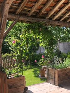 um jardim com uma pérgola de madeira e rosas rosas em Riverside Lodge em Chablis