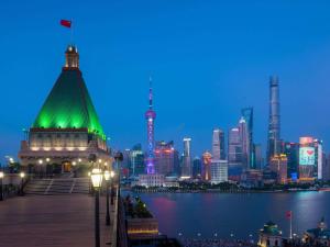 uma vista para o horizonte da cidade à noite em Fairmont Peace Hotel on the Bund em Xangai