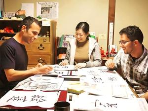 a group of three people sitting around a table at Guest House Pongyi in Kanazawa