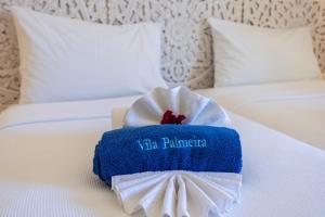 un asciugamano bianco e blu su un letto di Vila Palmeira Beach Resort a Lagos