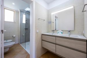 bagno con lavandino, servizi igienici e specchio di Vila Palmeira Beach Resort a Lagos