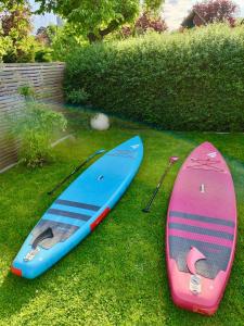 deux planches de surf assises sur l'herbe dans une cour dans l'établissement Ferienwohnung an der Nordsee, à Emden