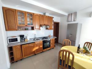 a kitchen with wooden cabinets and a table with a yellow tableablish at Villa Orada in Brela