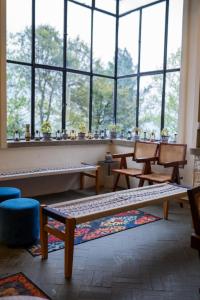 a room with tables and chairs and a large window at LOKAL Rooms x Murree Kashmir Point in Murree