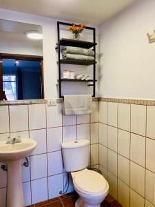 y baño con aseo y lavamanos. en Casa Pardo, en Cusco