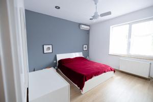 een slaapkamer met een bed met een rode deken bij Vila Agora in Dhërmi