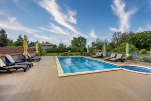 une piscine avec des chaises longues et une piscine dans l'établissement Apartments Brioni Colors, à Pula