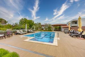 - une piscine avec des chaises et des parasols sur la terrasse dans l'établissement Apartments Brioni Colors, à Pula