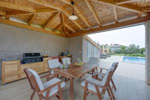 Il comprend une cuisine et une salle à manger avec une table et des chaises en bois. dans l'établissement Apartments Brioni Colors, à Pula