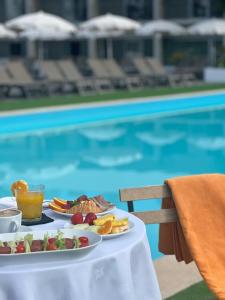 a plate of food on a table next to a pool at Alentejo Star Hotel - Sao Domingos - Mertola - Duna Parque Resorts & Hotels in Mina de São Domingos