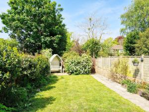 un jardin avec un banc et une clôture dans l'établissement Valetta Park, à Emsworth