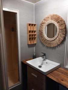 La salle de bains est pourvue d'un lavabo et d'un miroir. dans l'établissement Mobil home tout confort, à La Teste-de-Buch