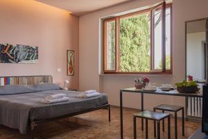 1 dormitorio con cama, mesa y ventana en La Bruna, en Porto Santo Stefano