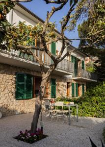 un árbol frente a un edificio con una mesa en La Bruna, en Porto Santo Stefano