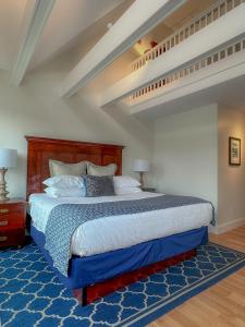 una camera con un grande letto con un tappeto blu di Harborside Inn a Newport