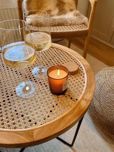 a table with two glasses of wine and a candle at 371living, Altbau-Charme am Kaßberg, Perfekt für Workation, Urlaub oder Kurztrip, Entdecke Chemnitz, Moderne Küche, Waschmaschine, Smart TV, Schnelles WLAN, Bequemes Bett in Chemnitz