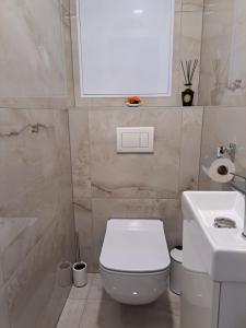 a bathroom with a white toilet and a sink at Tabáň Marble apartment (city center & free parking) in Nitra