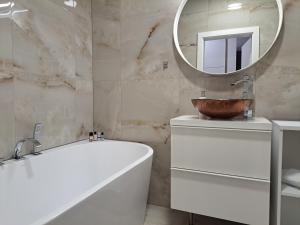 a bathroom with a tub and a sink and a mirror at Tabáň Marble apartment (city center & free parking) in Nitra