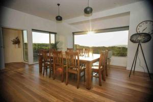 a dining room with a table and chairs and a clock at Martyrs Lookout - Luxury Accommodation in Peterborough