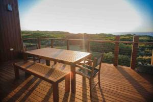 a wooden table and chair on a deck with a view at Martyrs Lookout - Luxury Accommodation in Peterborough