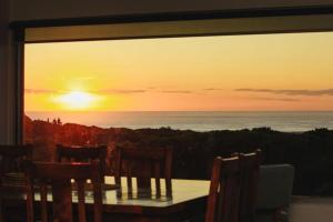 a table with chairs and a view of the ocean at Martyrs Lookout - Luxury Accommodation in Peterborough