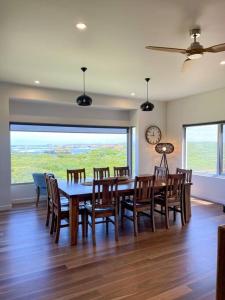 a dining room with a table and chairs and a clock at Martyrs Lookout - Luxury Accommodation in Peterborough